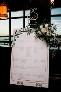 Wedding seating chart decorated in winter greenery