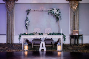 Wooden branch arch adorned with winter greenery